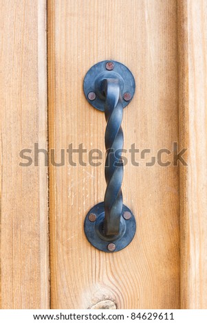 Metallic black soaring door knob on a brown door