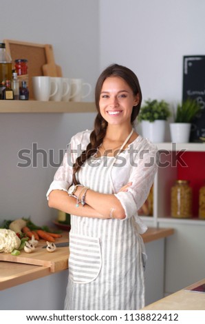 Young woman standing near desk in the kitchen. Young woman .