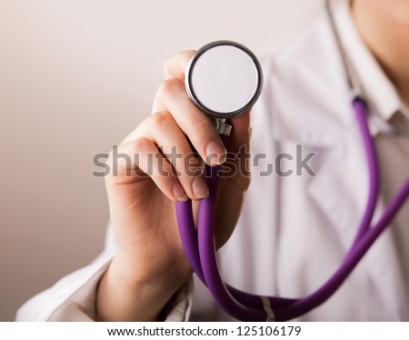 Close-up of female doctor using stethoscope , focus on stethoscope