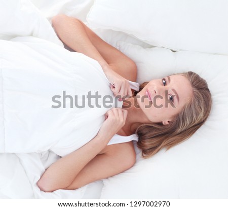 Young sleeping woman and alarm clock in bedroom at home. Young sleeping woman.