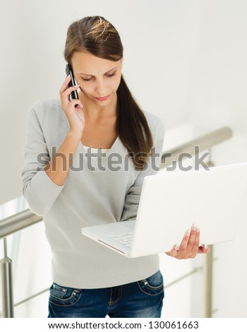 woman work on laptop and talking on the phone