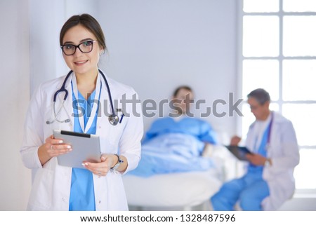 Female doctor using tablet computer in hospital lobby