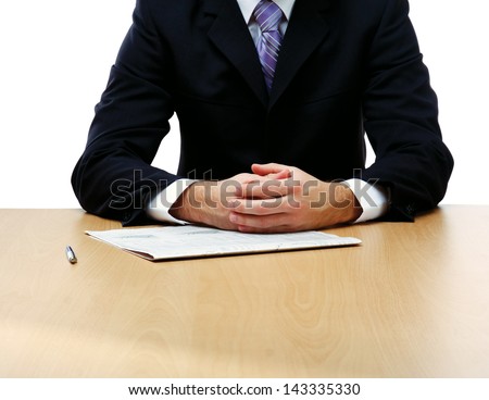 Unknown businessman sitting on the desk with documents