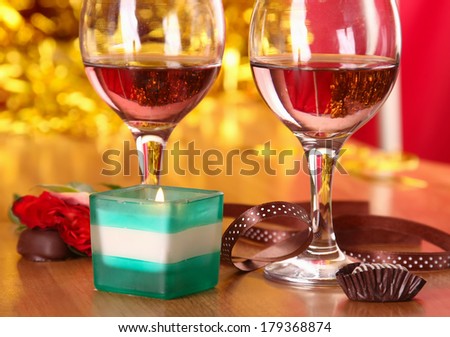 christmass dinner with rose candies and two glasses of red wine