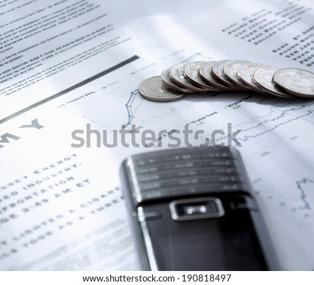 Coins and mobile phone on the document