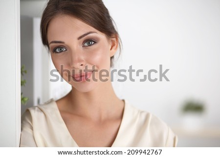 Close-up portrait of a smiling  business woman standing in her office
