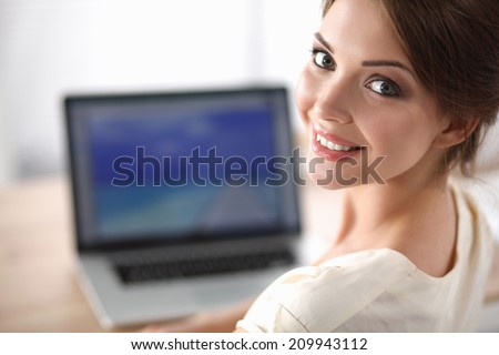 Portrait of beautiful young business woman working on a laptop at office