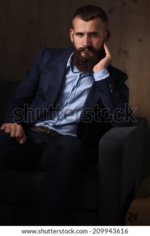 Businessman sitting the sofa in office lobby, isolated on dark background