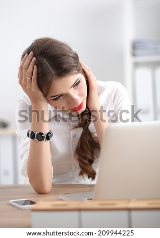 Tired woman in front of a laptop sitting on the desk