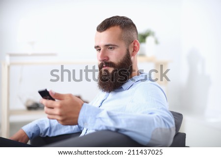 Businessman sitting the sofa in office lobby with phone, isolat