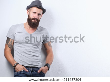 Portrait of handsome bearded man in hat standing , isolated on