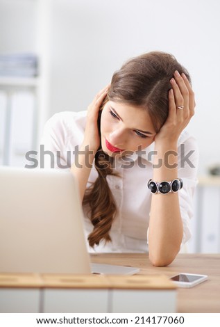Tired woman in front of a laptop sitting on the desk