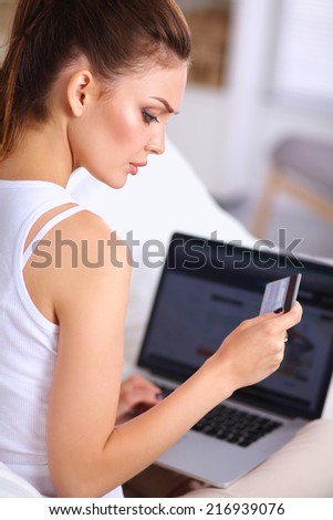 Woman shopping online with credit card and computer.