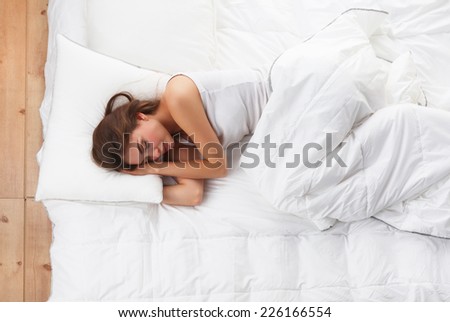 Beautiful girl sleeps in the bedroom, lying on bed, isolated