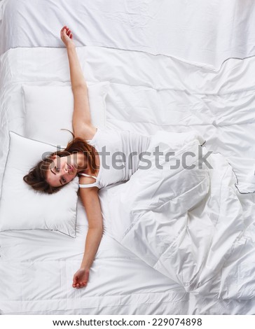 Beautiful girl lying in bedroom at early morning , isolated