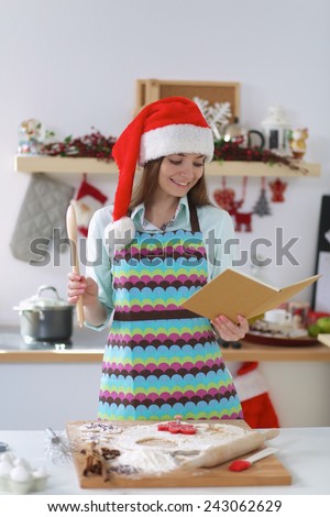 Christmas baking santa woman smiling happy having fun with Christmas preparations wearing Santa hat