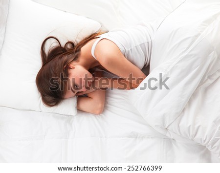 Beautiful girl sleeps in the bedroom, lying on bed .