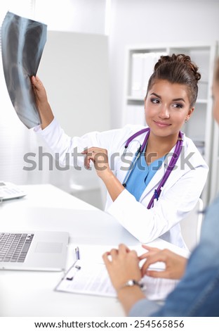Doctor and patient sitting on the desk at office .