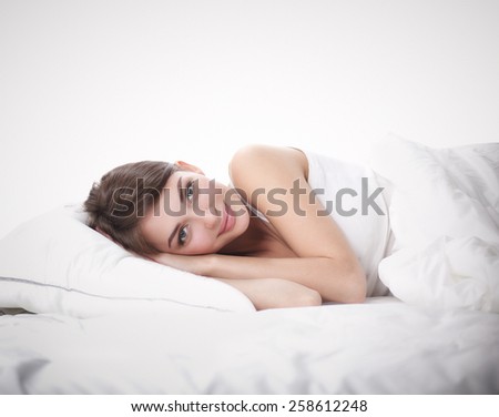 Beautiful girl lying in bedroom at early morning.