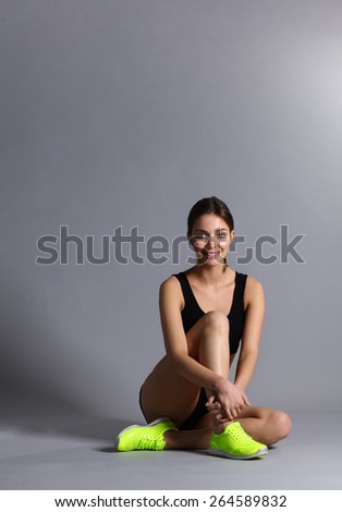 Woman sitting with crossed legs on the floor.