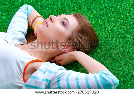 Top view of beautiful young woman holding hands behind head.