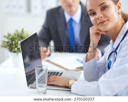 Medical team sitting at the table in modern hospital .