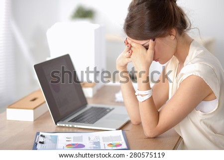Portrait of tired young business woman with laptop computer
