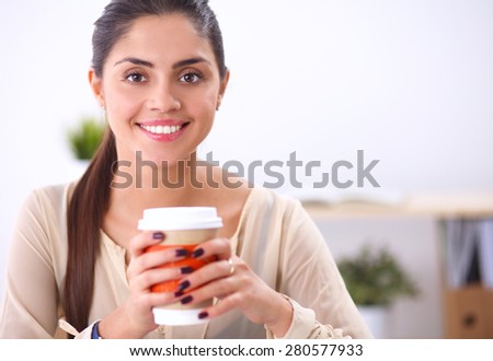 Portrait of a young woman with cup of tea or coffee, isolated