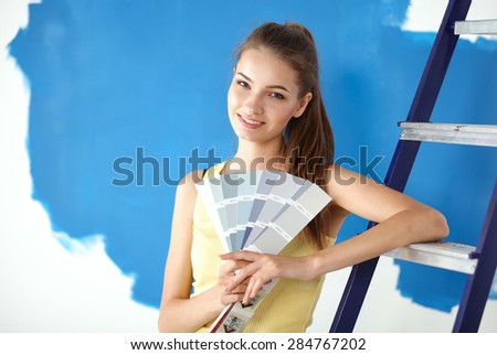 Young beautiful woman holding color palette with color samples.