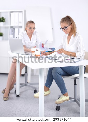 Two women working together at office, sitting
