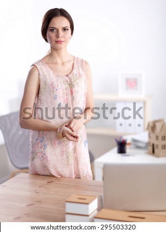 Close-up portrait of a smiling business woman standing in her office.