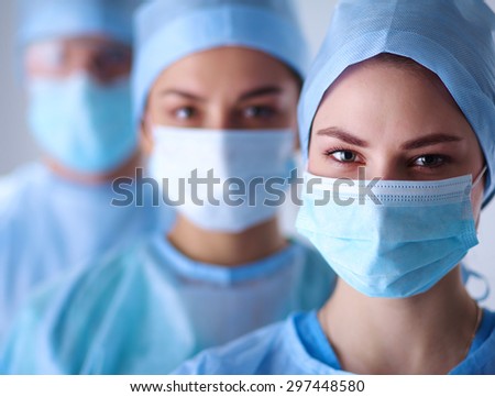 Surgeons team, man and woman wearing protective uniforms,caps and masks.