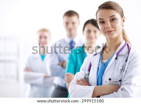 Attractive female doctor in front of medical group .