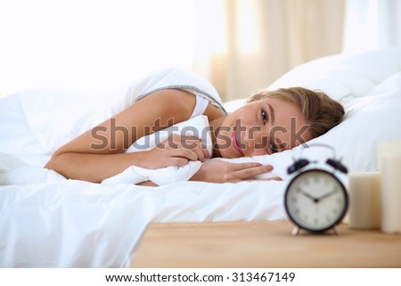 Woman can not sleep.Clock on the desk
