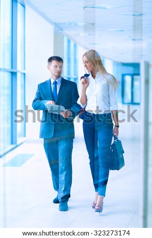 Business people walking in the corridor of an business center, cool tone