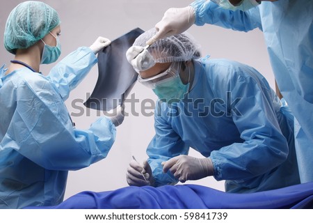 Below view of surgeons holding medical instruments in hands