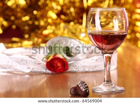 christmass dinner with rose candies and glass of red wine