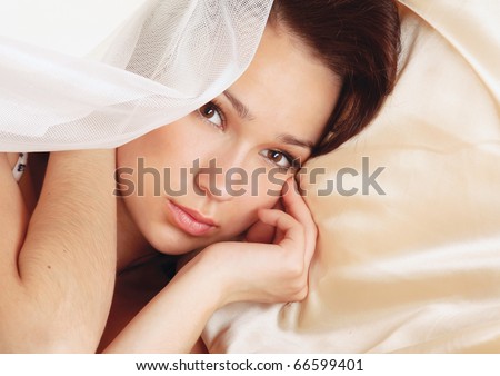 Beautiful smiling woman on bed at bedroom