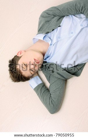 A young handsome college guy lying on the floor