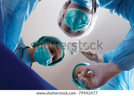 Below view of surgeons holding medical instruments in hands, isolated on grey