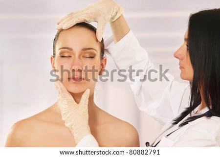 Cosmetic medicine, a doctor is examining patient\'s face