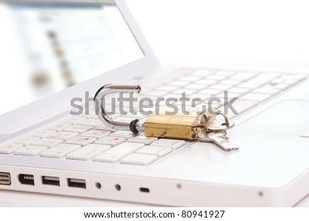 An open lock with keys on a laptop