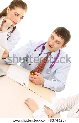 Doctor and Nurse sitting at computer giving prescription to the patient.  Isolated over white background