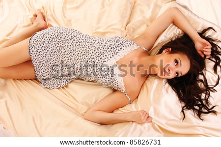Top view of relaxed young woman in nightgown lying in her bed