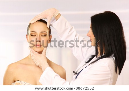 Cosmetic medicine, a doctor is examining patient's face