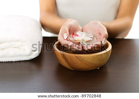 Woman's hands holding flower on bowl of water