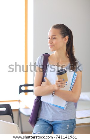 Portrait of young student woman holding exercise books. Student woman