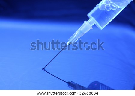 syringe with needle stuck in water