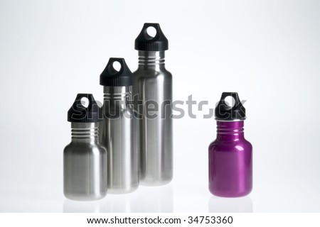 Three silver stainless steel water bottles and one fuschia.
