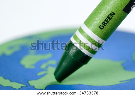 Green crayon against drawing of the earth.